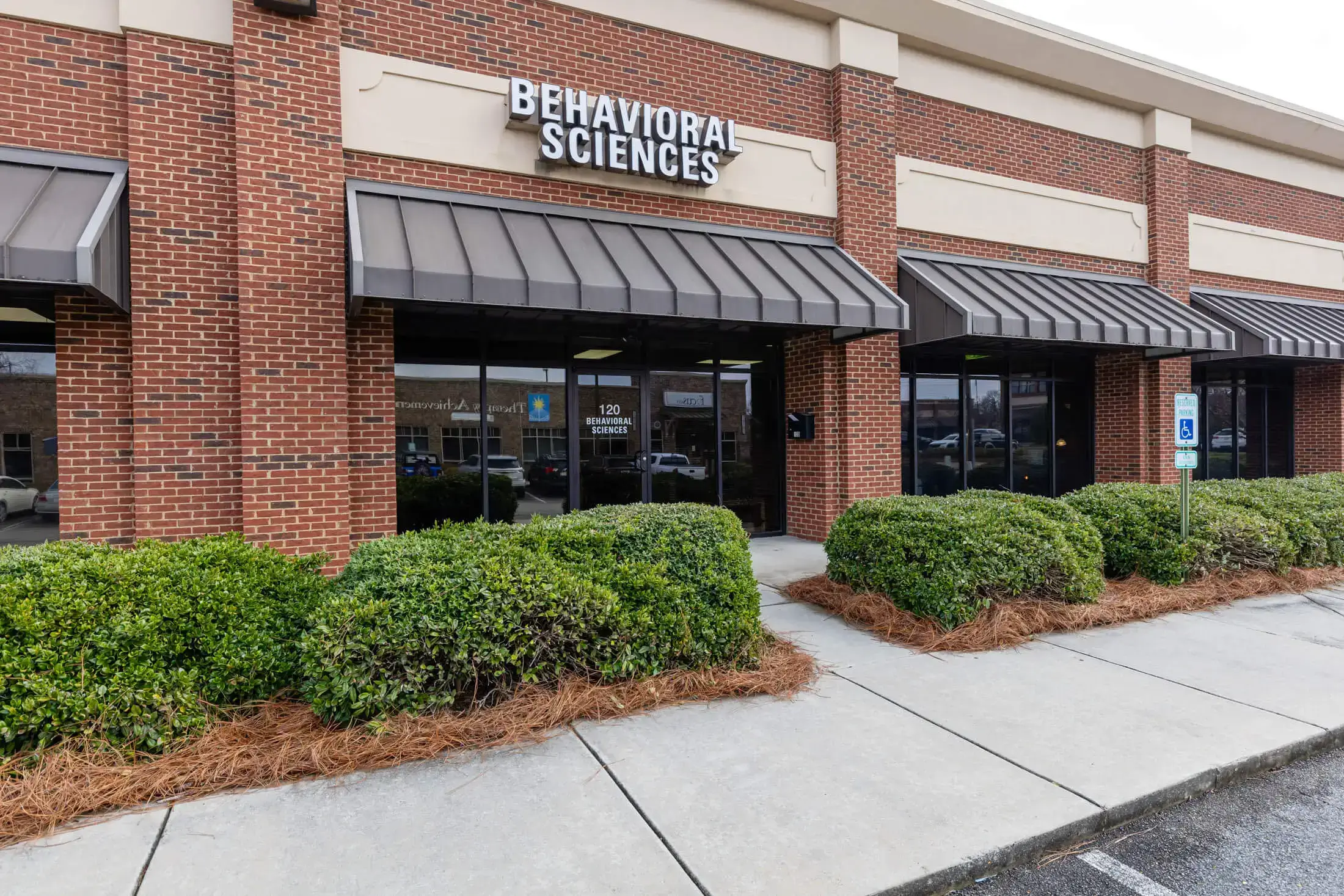 Brick building with "Behavioral Sciences" sign.