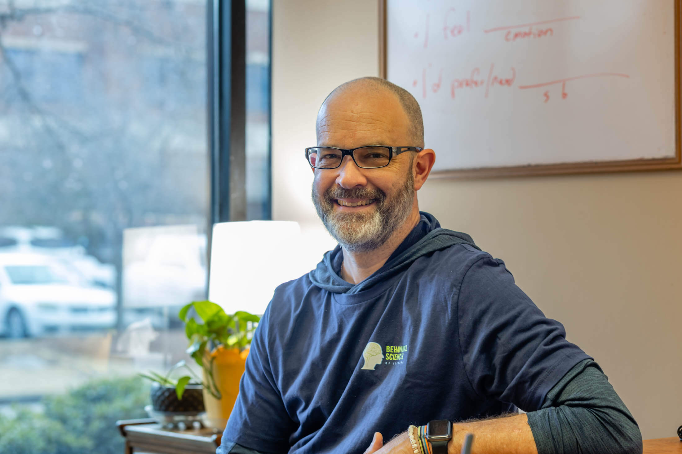 Man smiling in an office environment.