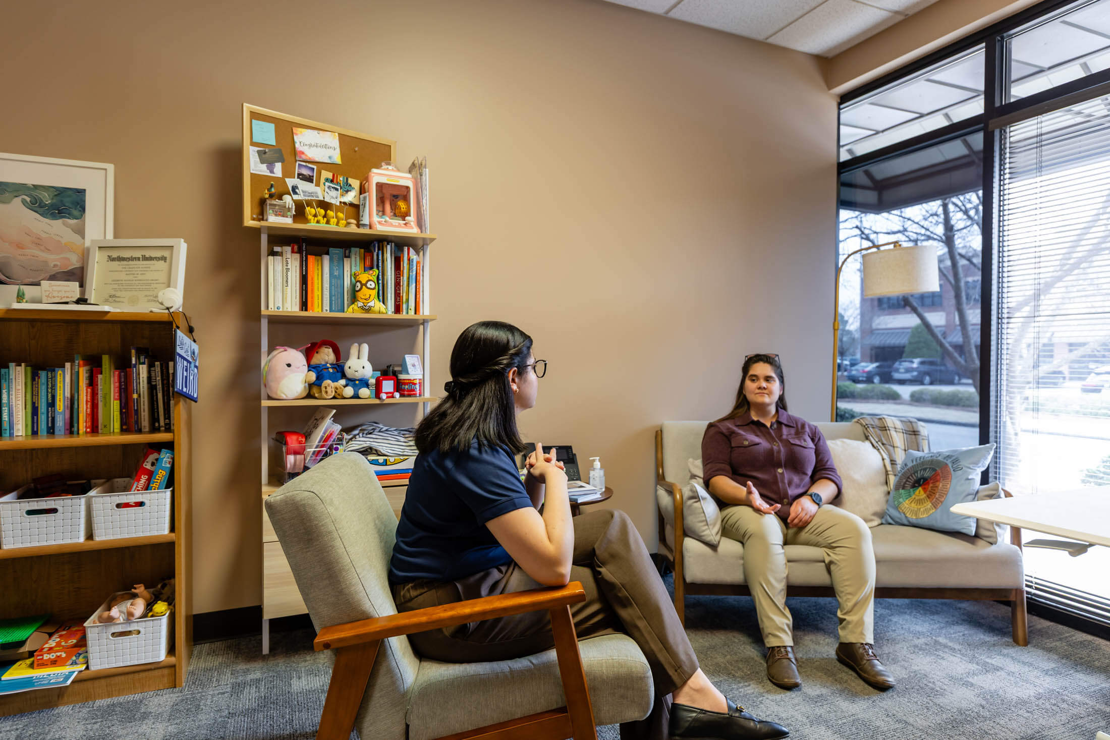 Two people talking in a cozy office.